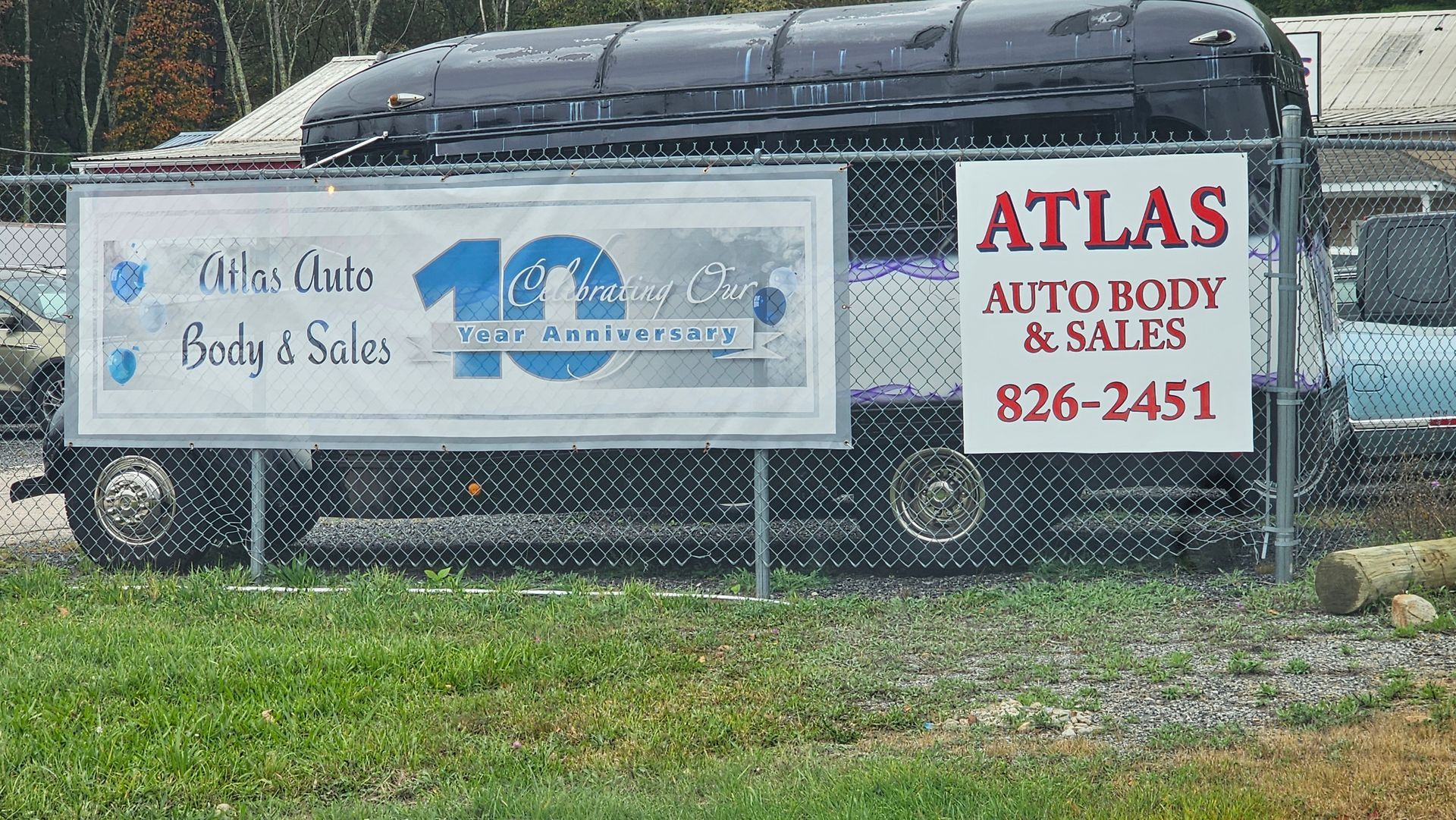 A sign that says atlas auto body and sales on it