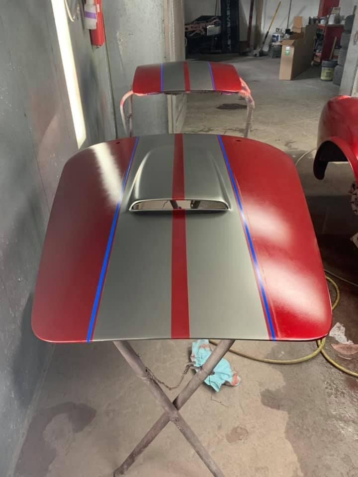 A red and gray table with a hood on it in a garage.