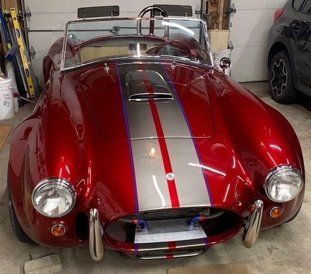 A red and silver sports car is parked in a garage