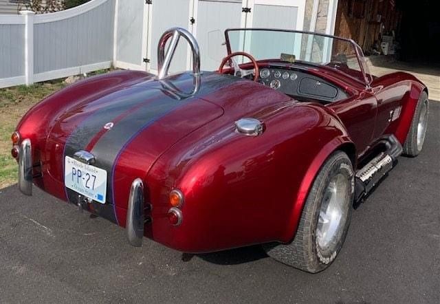 A red sports car with a license plate that says pp-27