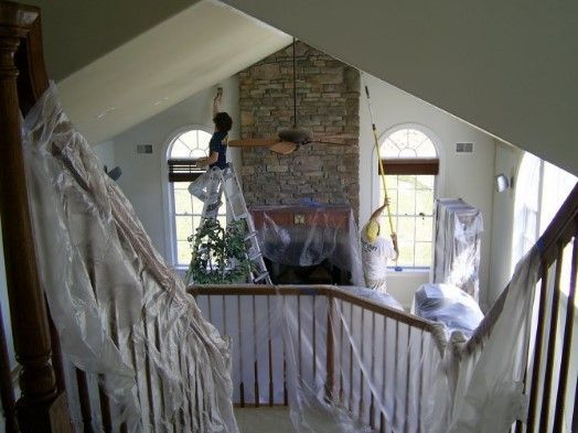 Attic interior with vaulted ceiling, brick chimney, and draped white fabric along a railing