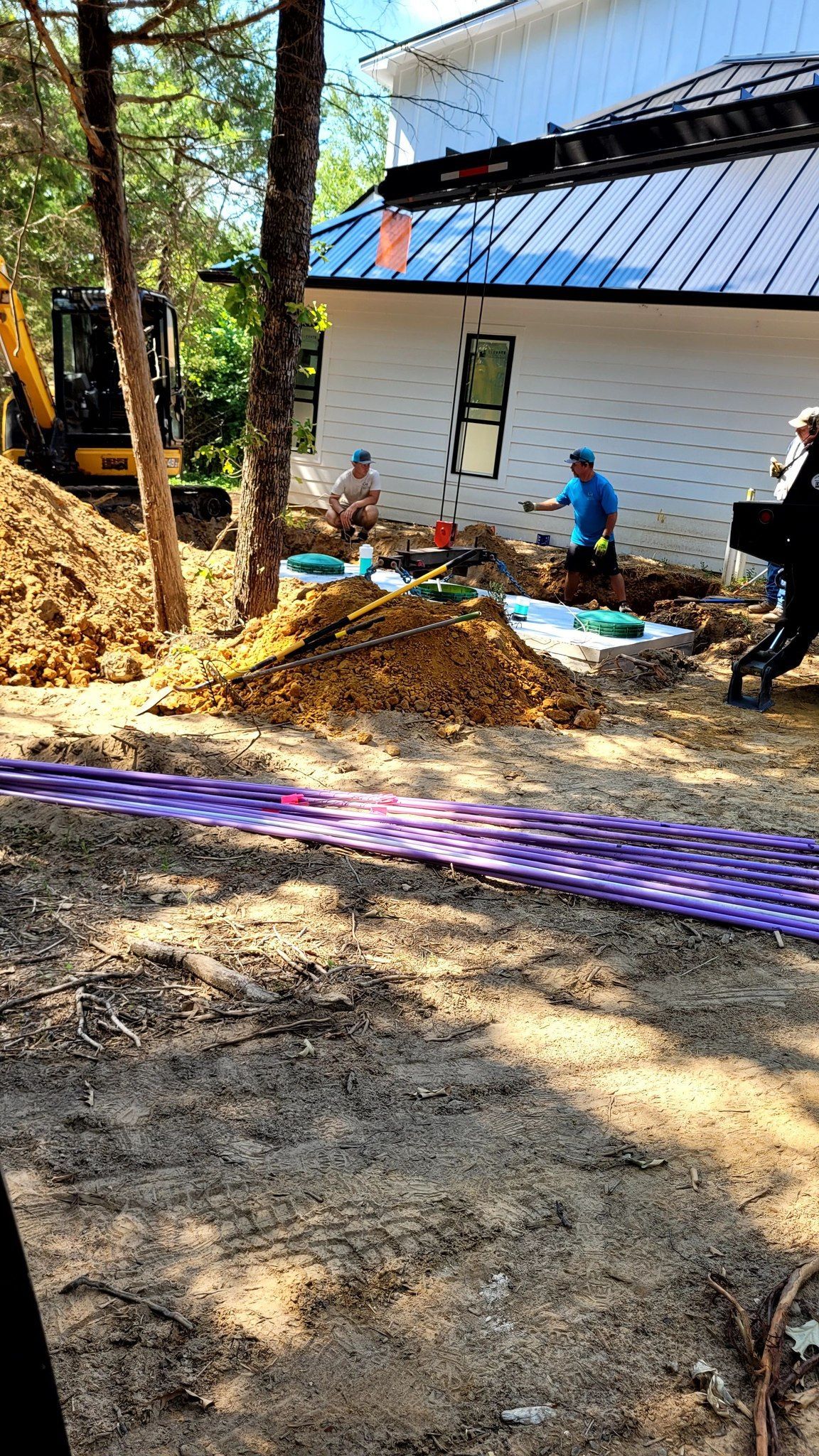 a man sitting on a pile of dirt in front of a house