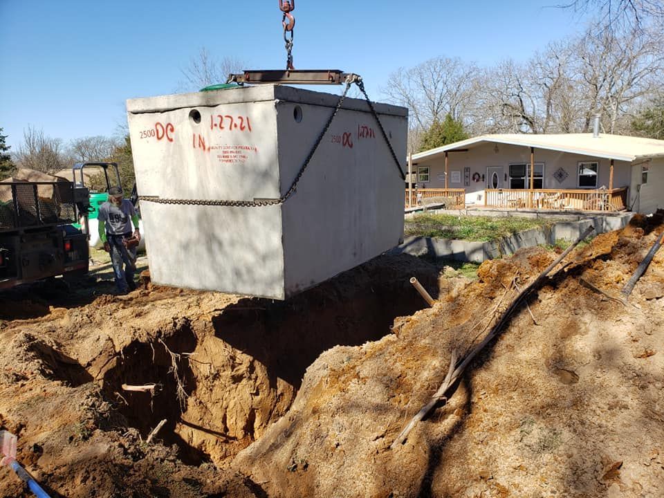 a concrete septic tank is being lifted into the ground