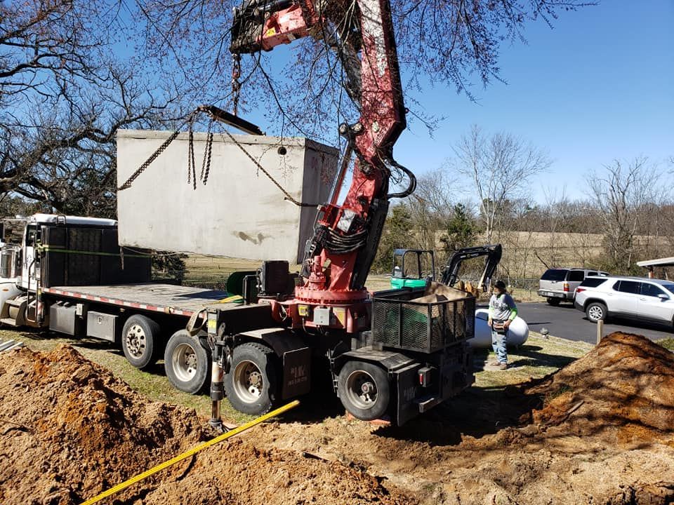 a crane is lifting a large concrete box on top of a flatbed truck