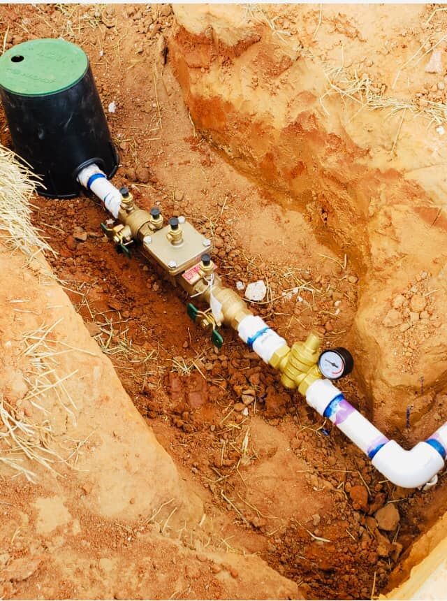 a pipe with a gauge attached to it is in the dirt