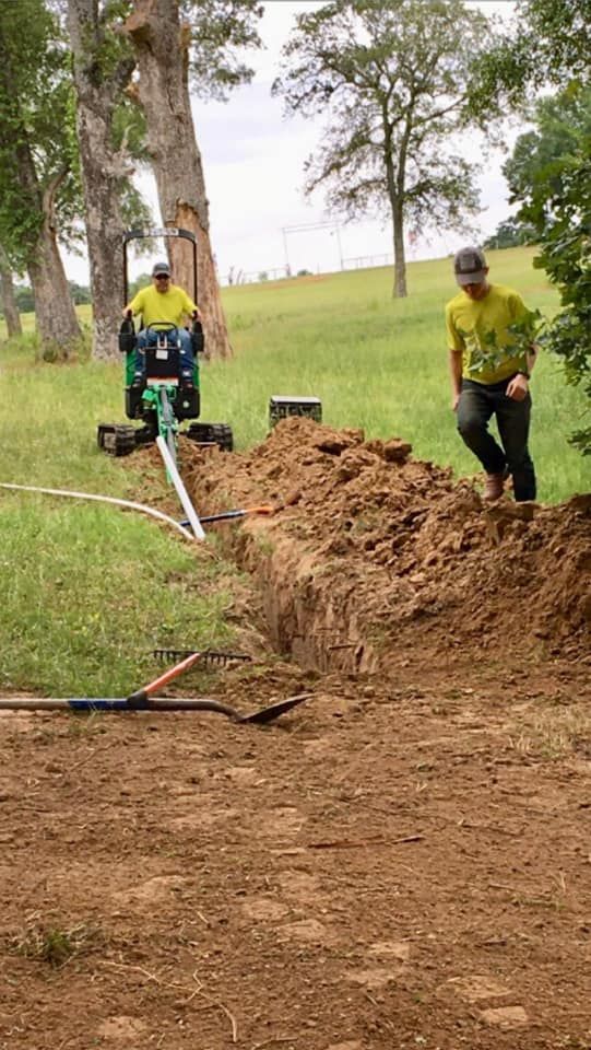 a man in a yellow shirt is standing next to a green tractor