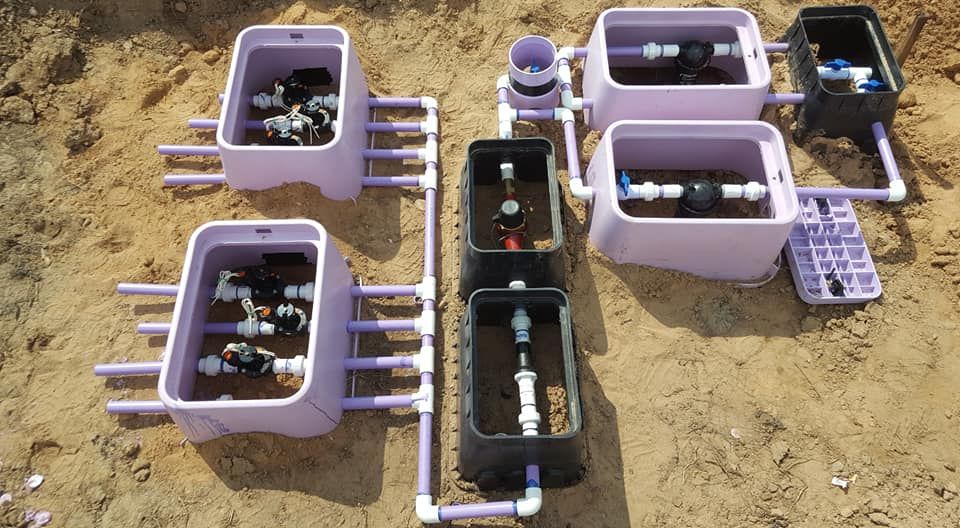 a bunch of boxes filled with pipes and valves on the ground