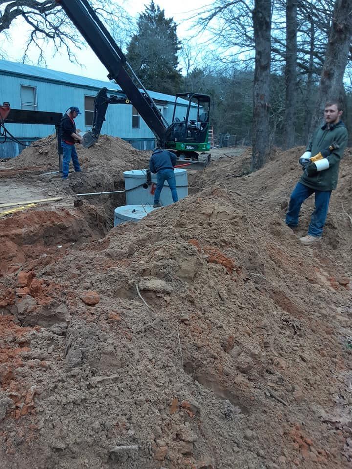 a man standing in a pile of dirt next to a tractor