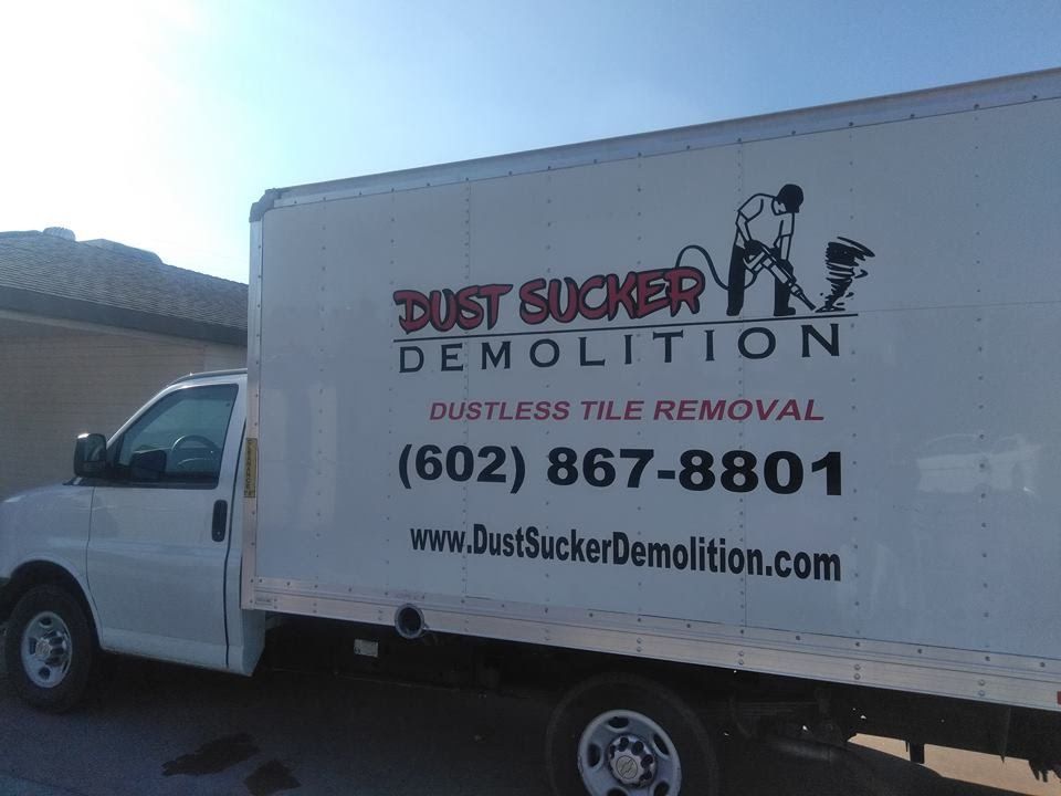 A white truck with dust sucker demolition written on the side