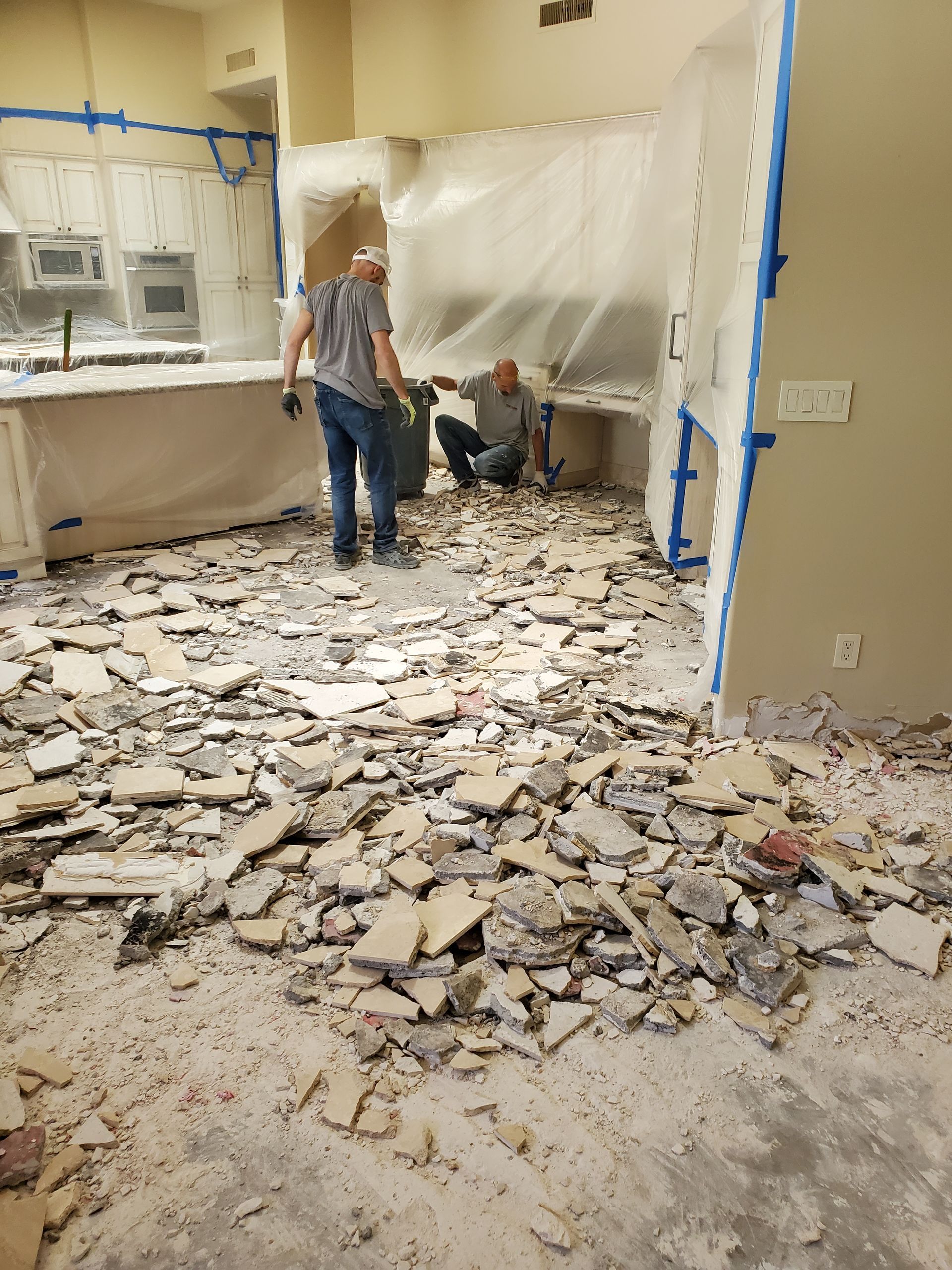 Two men are working on the floor of a building.