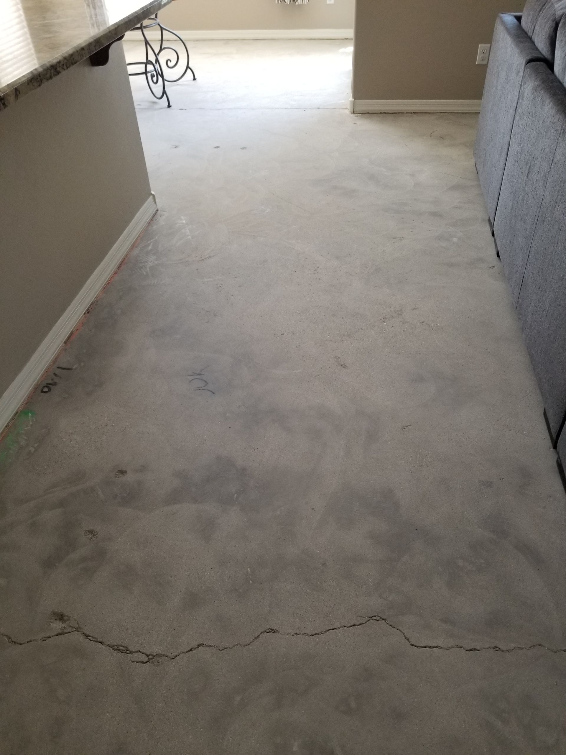 A gray carpeted floor in a living room with a couch and a table.