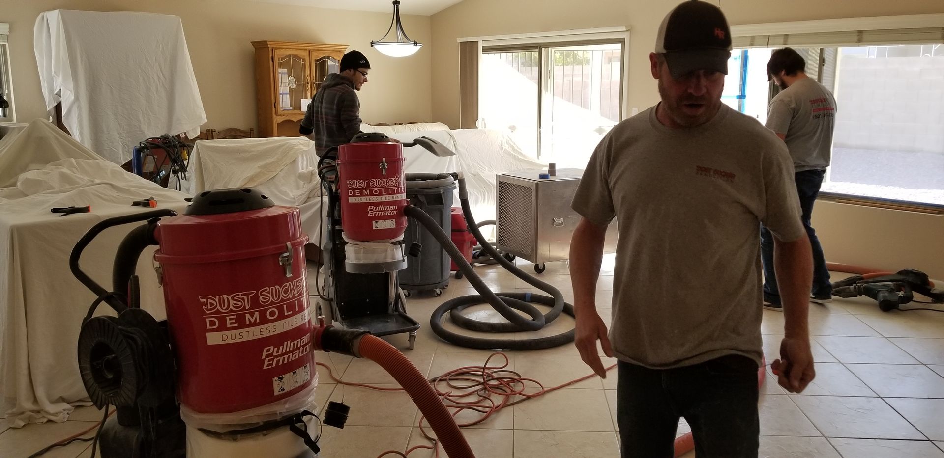 A man is standing in a room with a vacuum cleaner.