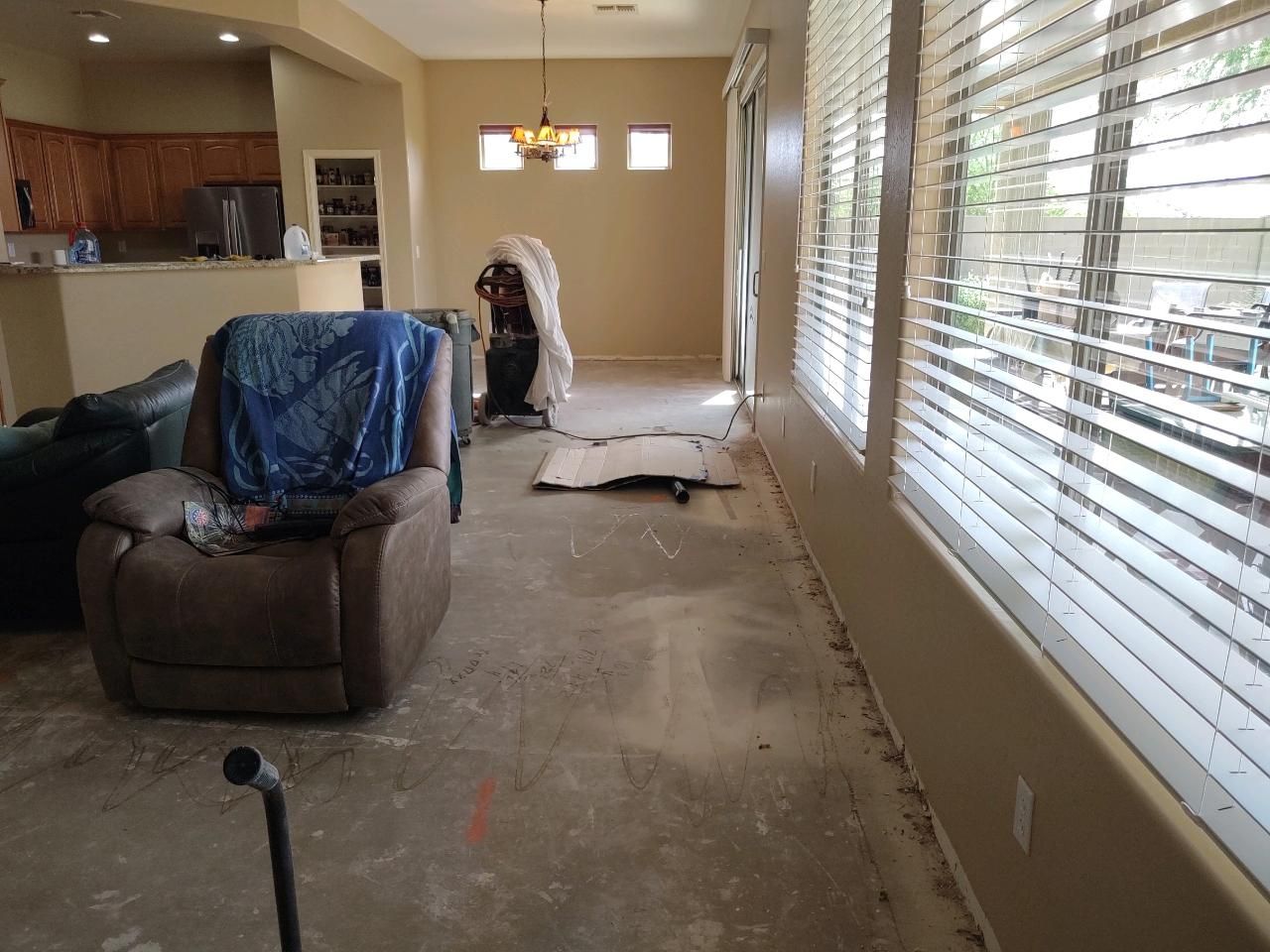 A living room with a couch, chair, and blinds.