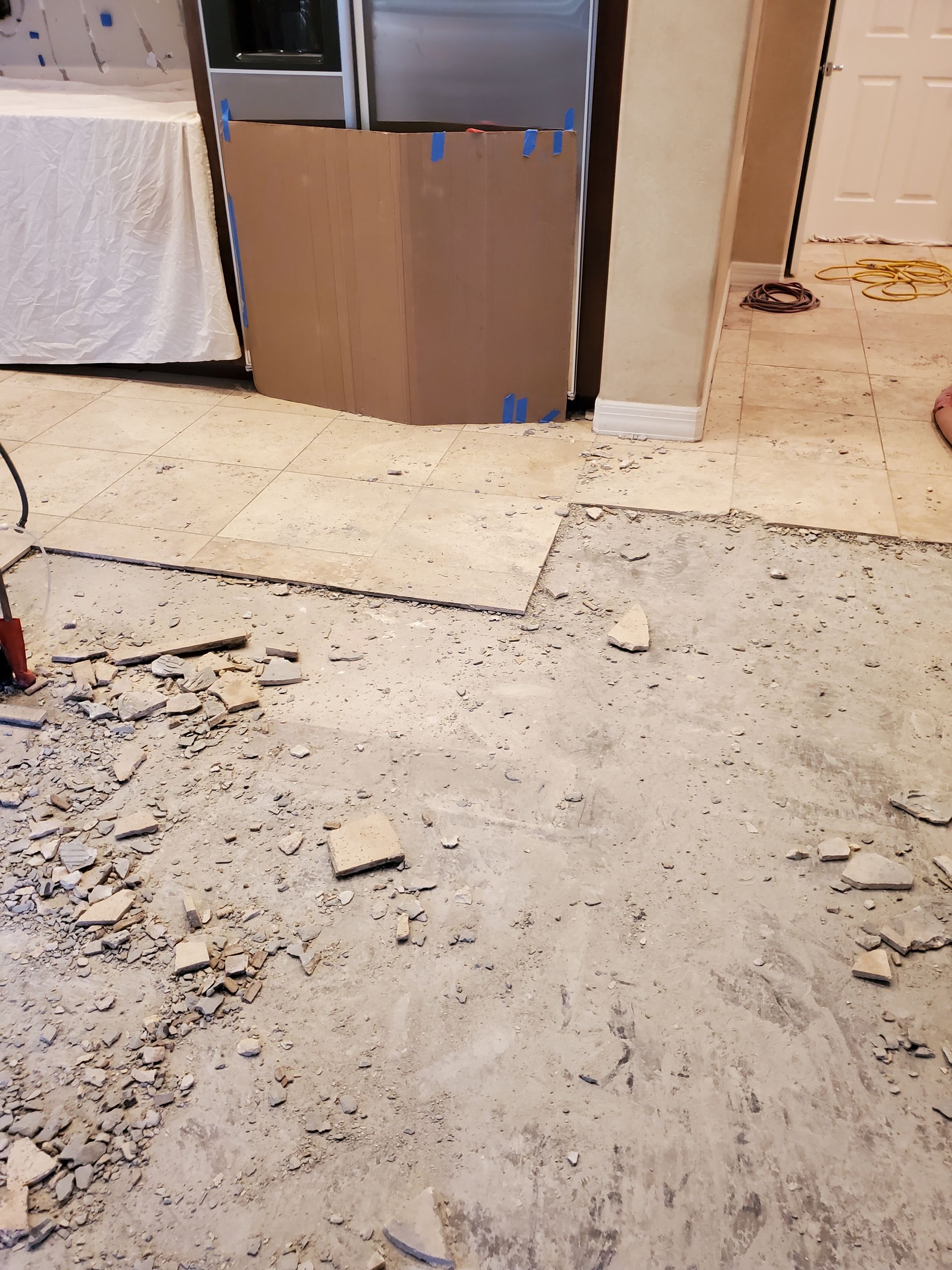 A person is working on a concrete floor in a kitchen.