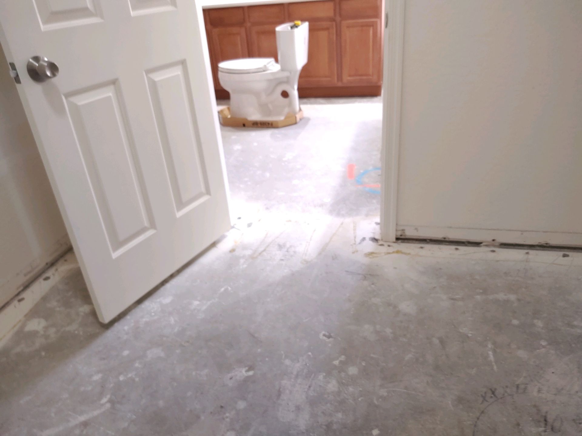 A bathroom with a toilet and a door open