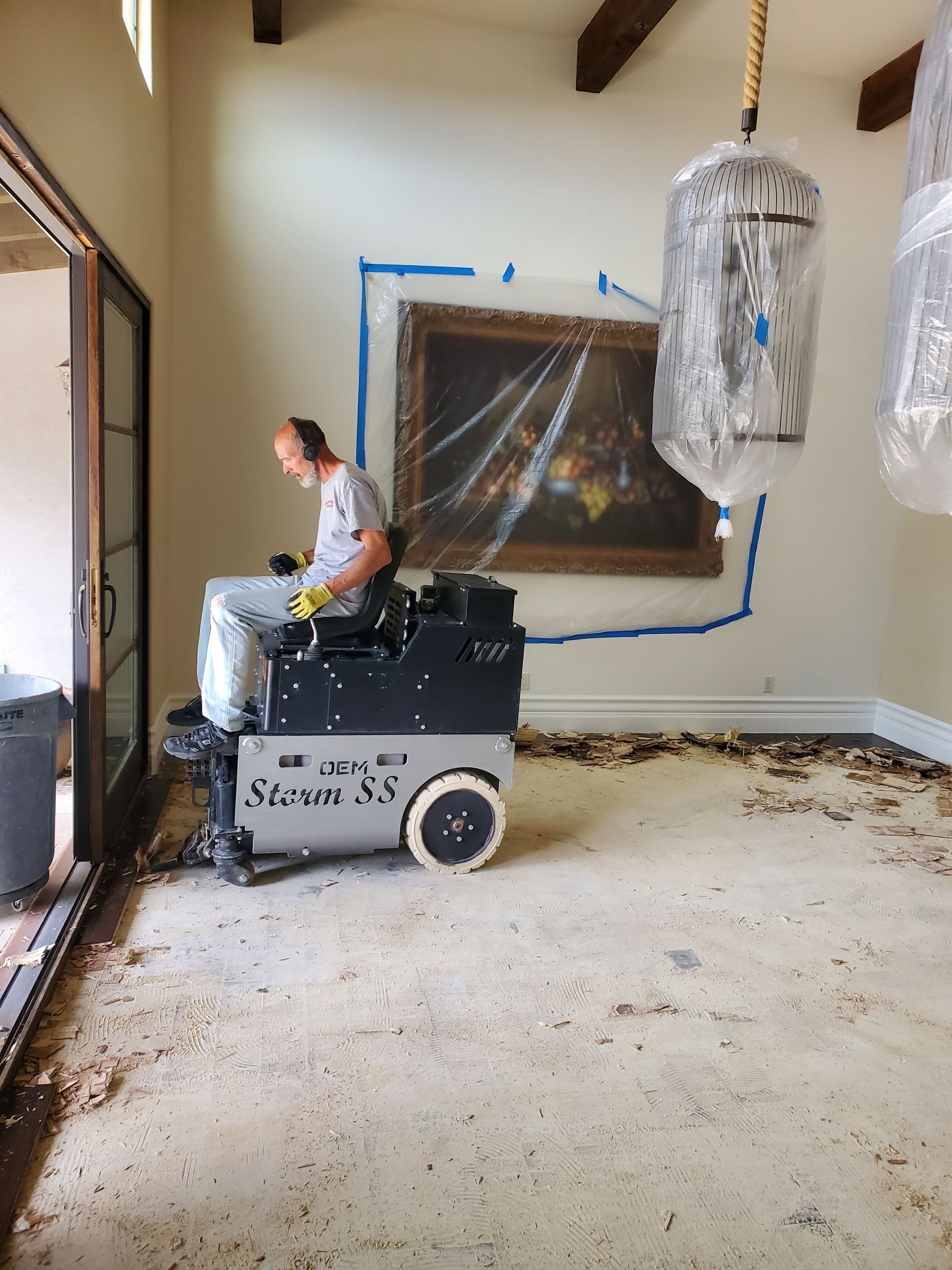 A man is riding a machine in a room with a painting on the wall.