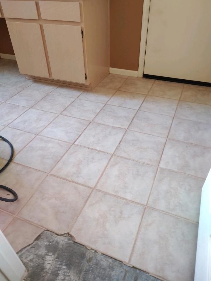 A kitchen with tile floors and cabinets and a door.
