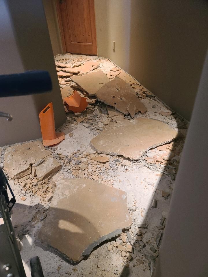 A room with a lot of broken tiles on the floor.
