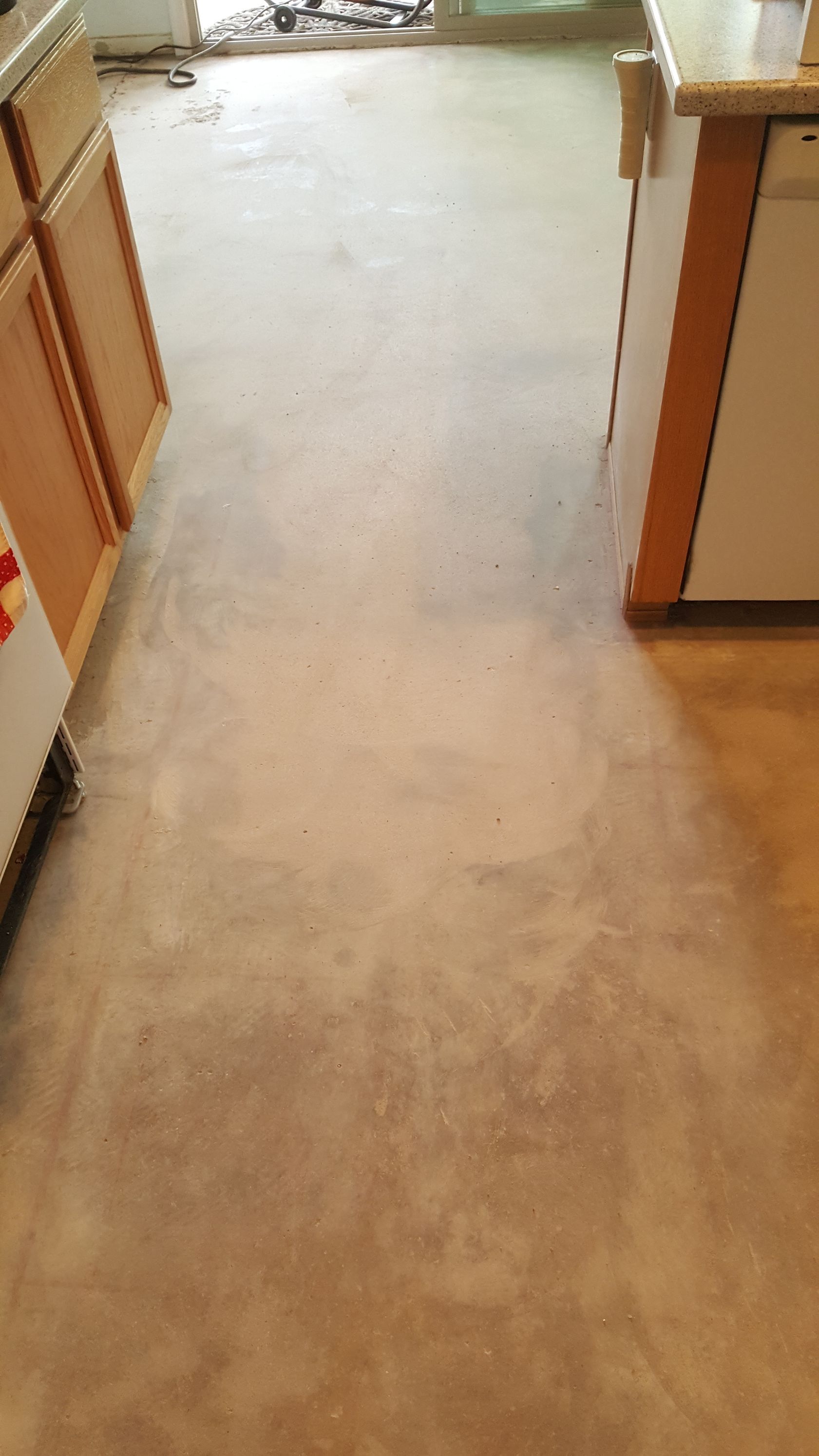 A kitchen with a carpeted floor and wooden cabinets.