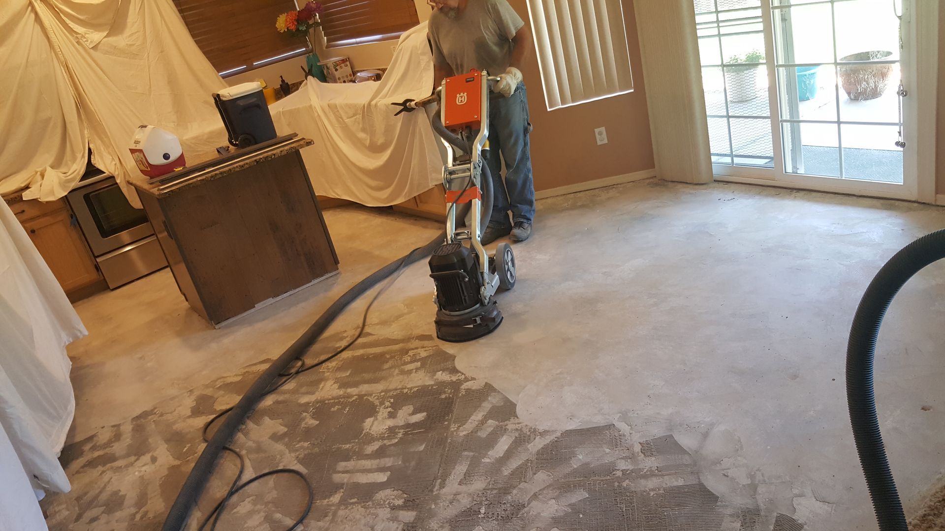 A man is using a vacuum cleaner to clean the floor in a living room.