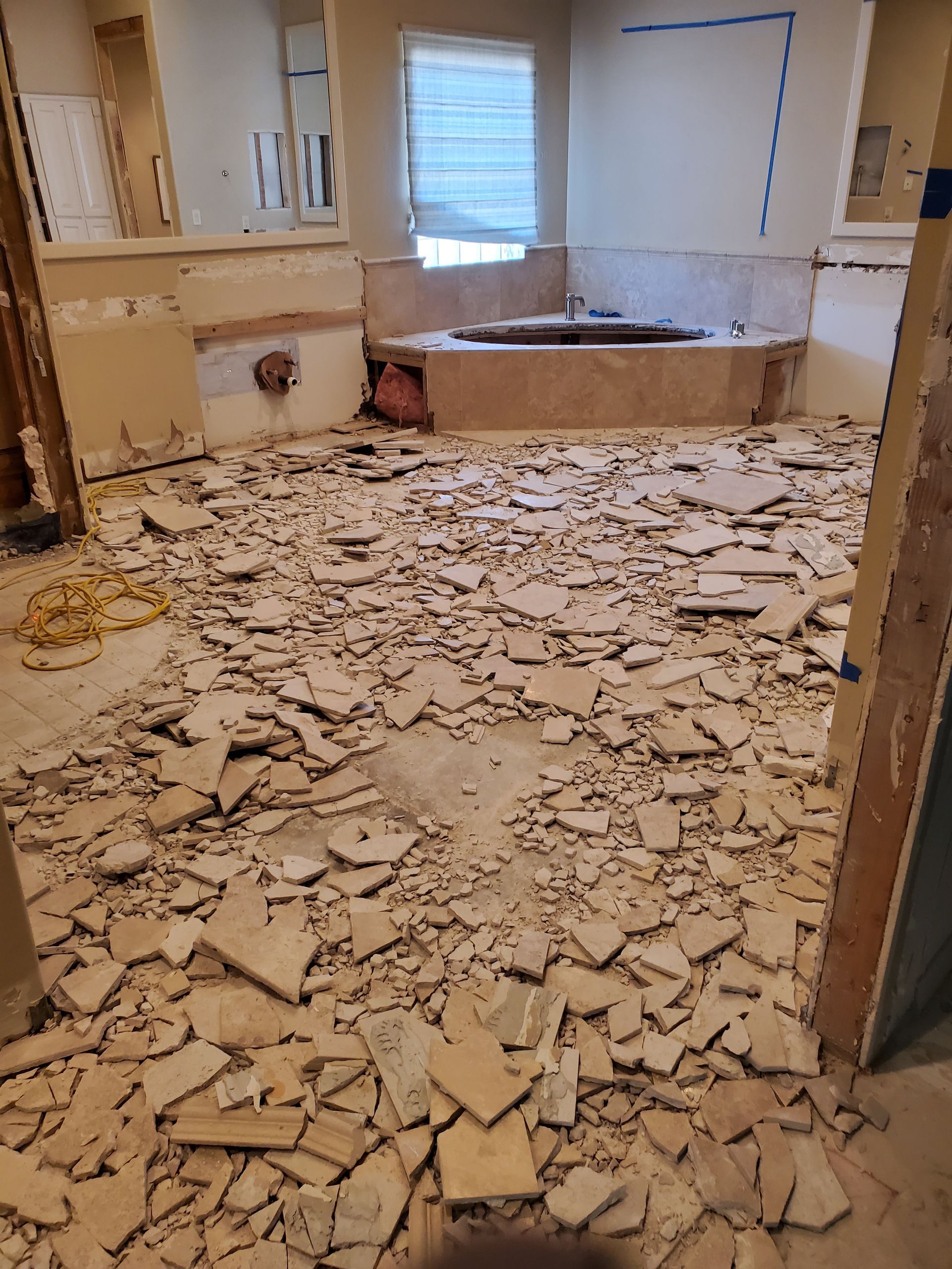 A bathroom with a bathtub and a lot of tiles on the floor.