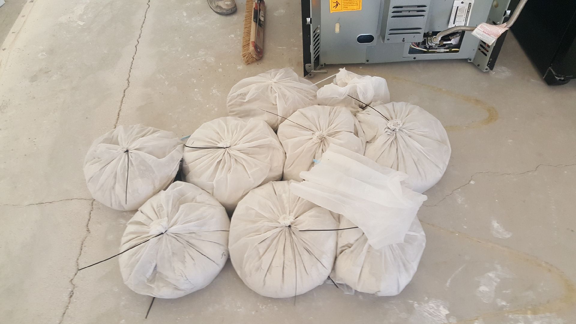 A bunch of white bags are sitting on the floor