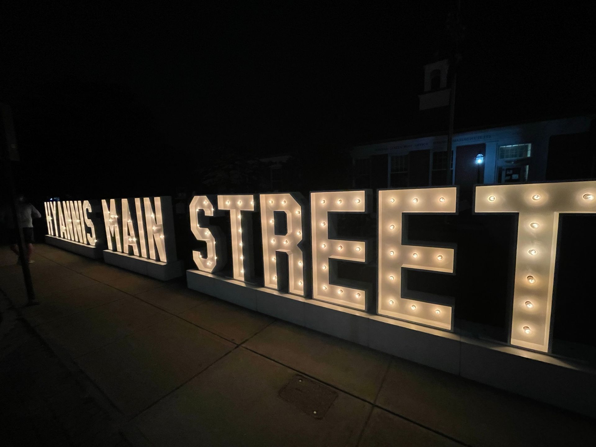Campus Main Street sign with illuminated letters at night.