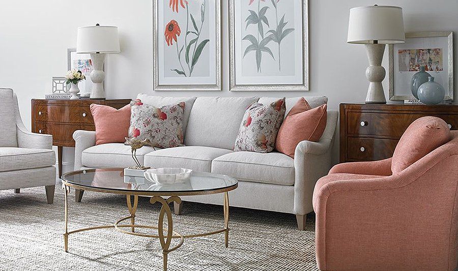 A living room with a couch , chairs , and a coffee table.