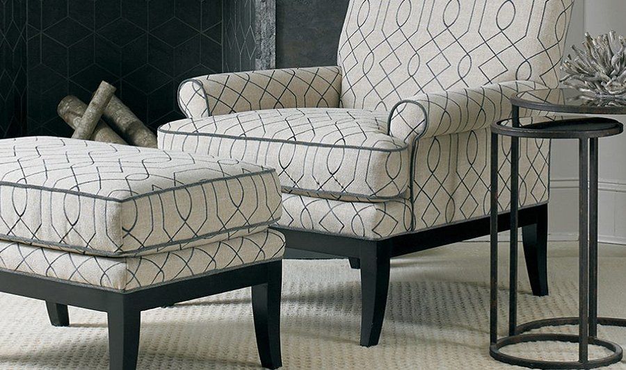 A chair and ottoman in a living room with a fireplace in the background