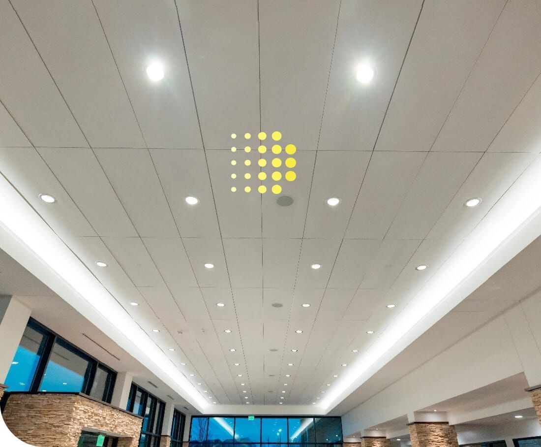 a long hallway in a hospital with a clock on the ceiling