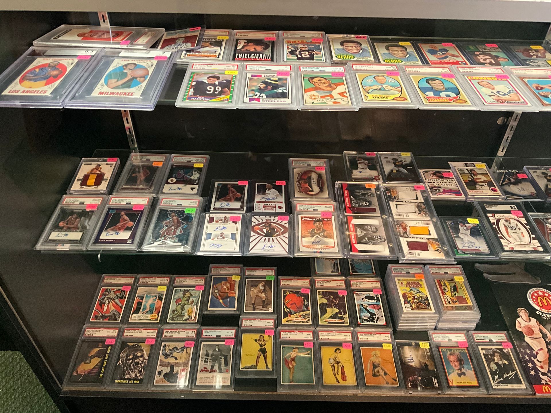 Display case filled with sports trading cards in protective cases.
