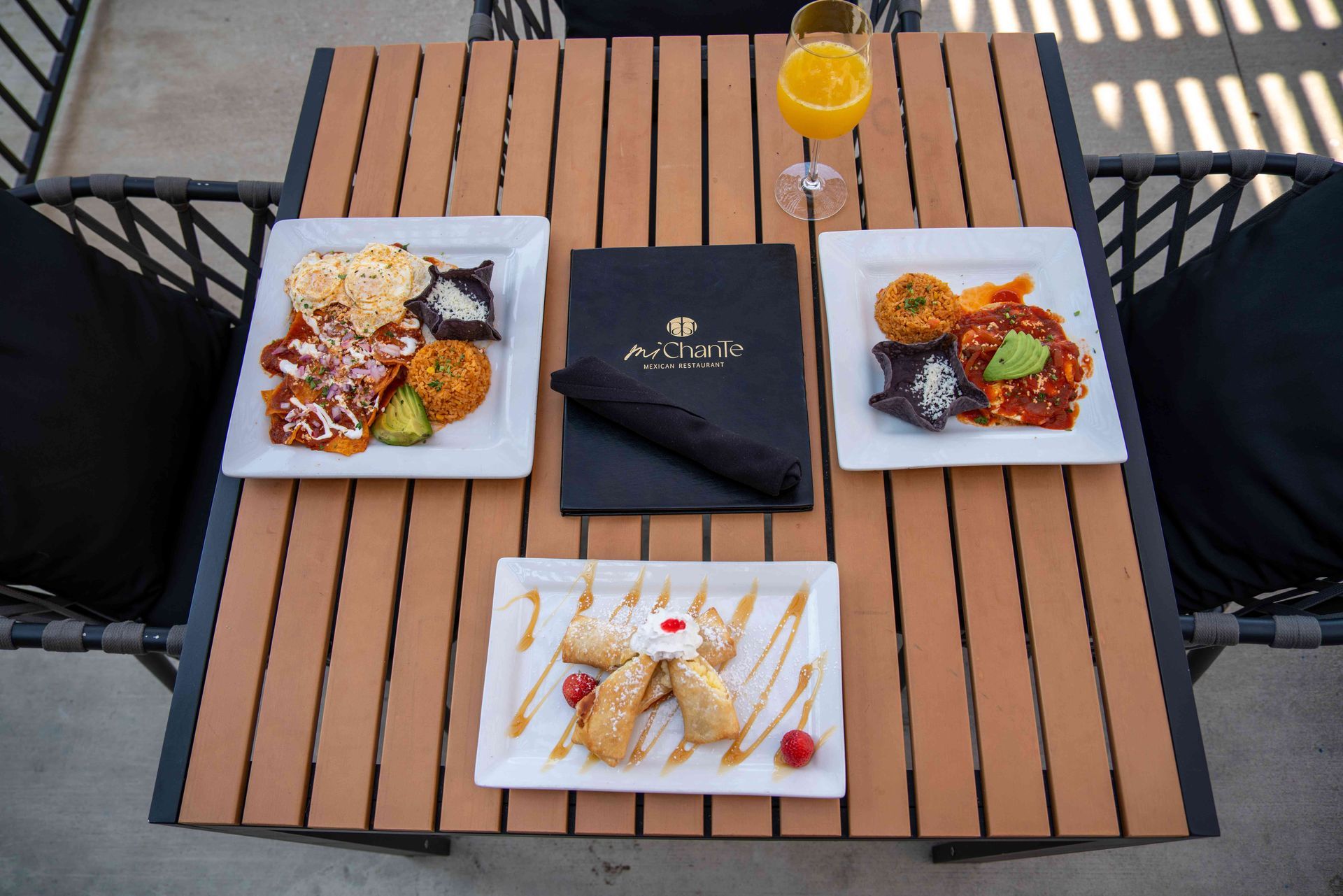 Overhead view of a table with brunch dishes and a mimosa.