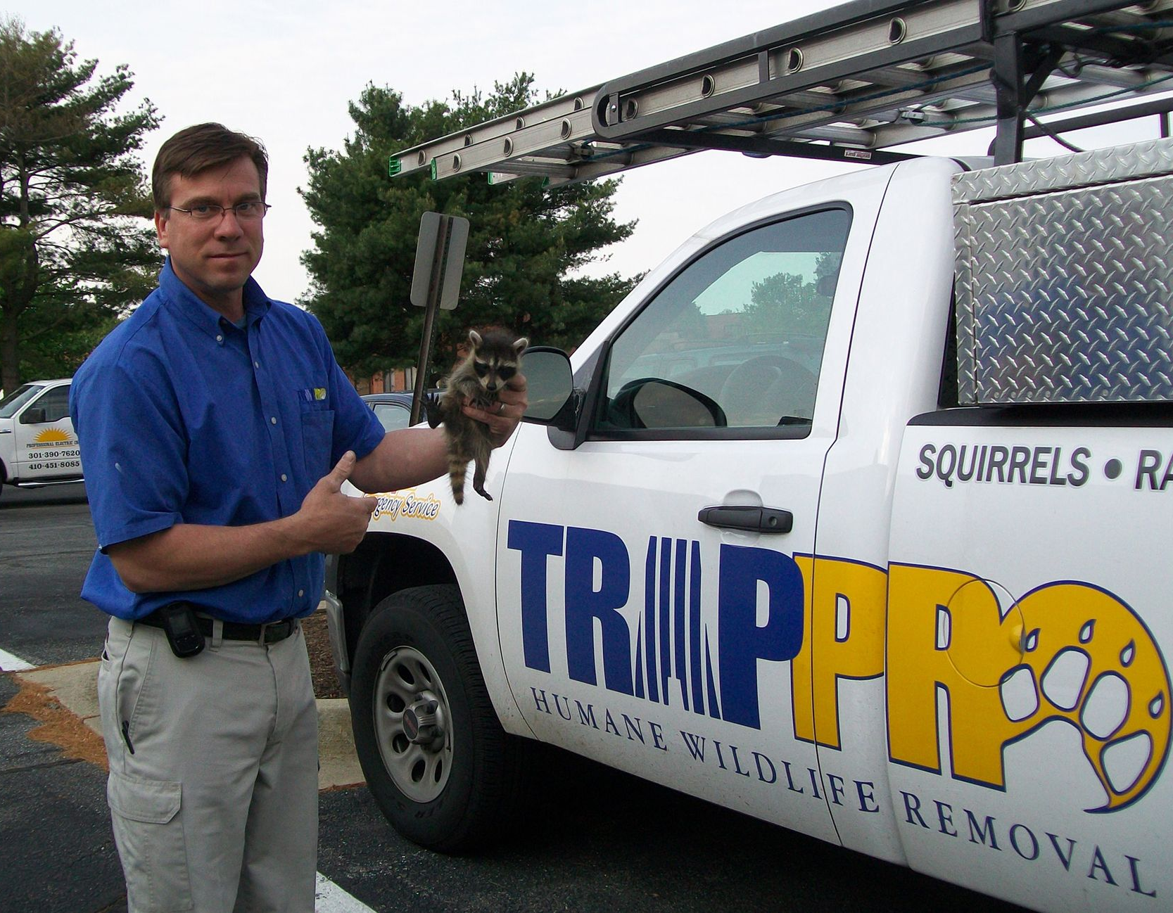 Man holding small animal next to 