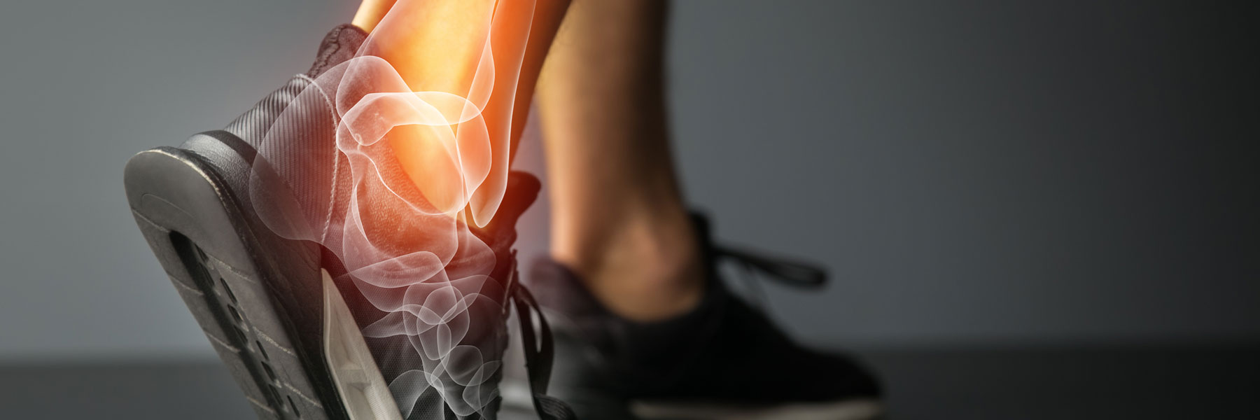 Foot in a black sneaker with a highlighted ankle, possibly indicating pain or injury.