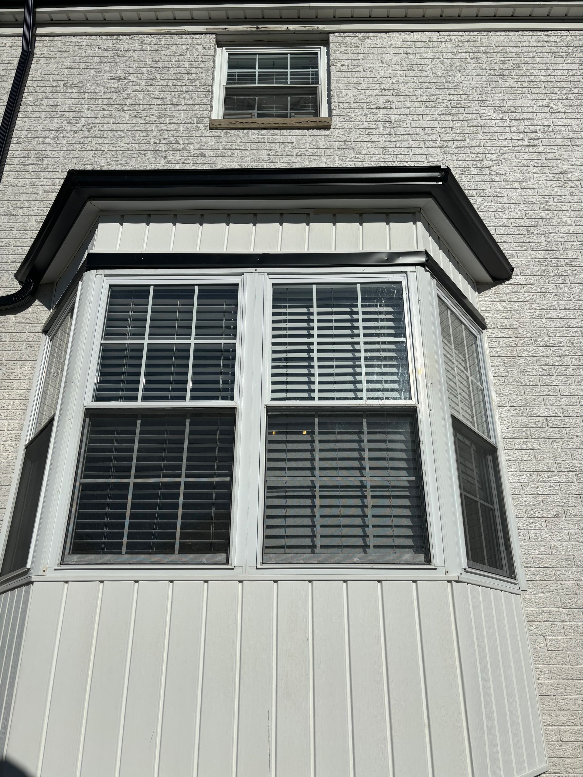 A large bay window on the side of a brick building