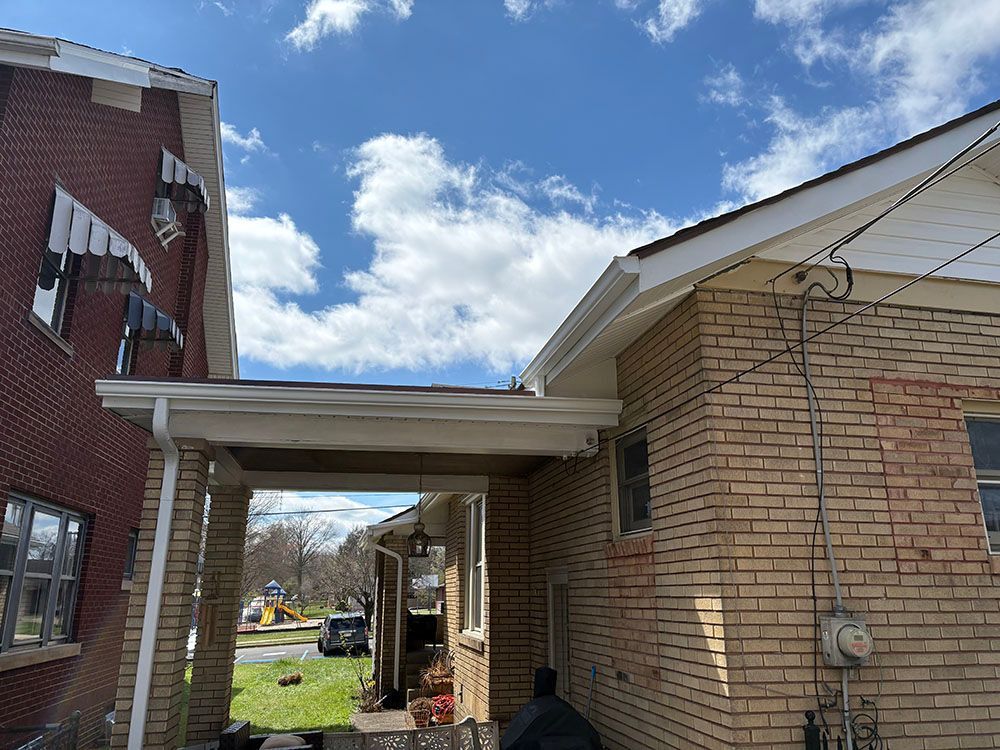 Covered brick walkway between two buildings on a sunny day with blue sky and clouds.