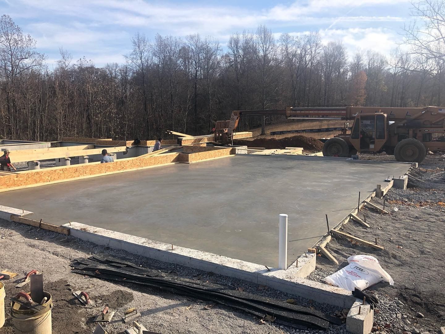 Concrete foundation, freshly poured, with wooden frame, awaiting construction, outdoors.