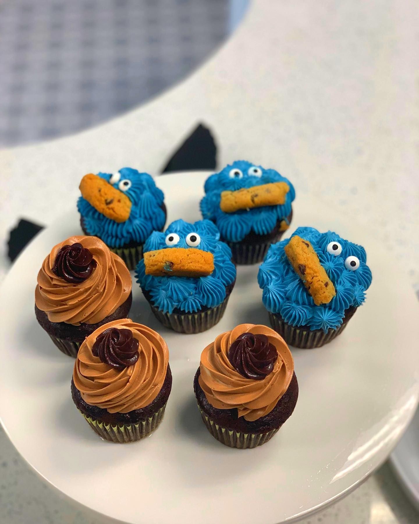 A white plate topped with cookie monster cupcakes