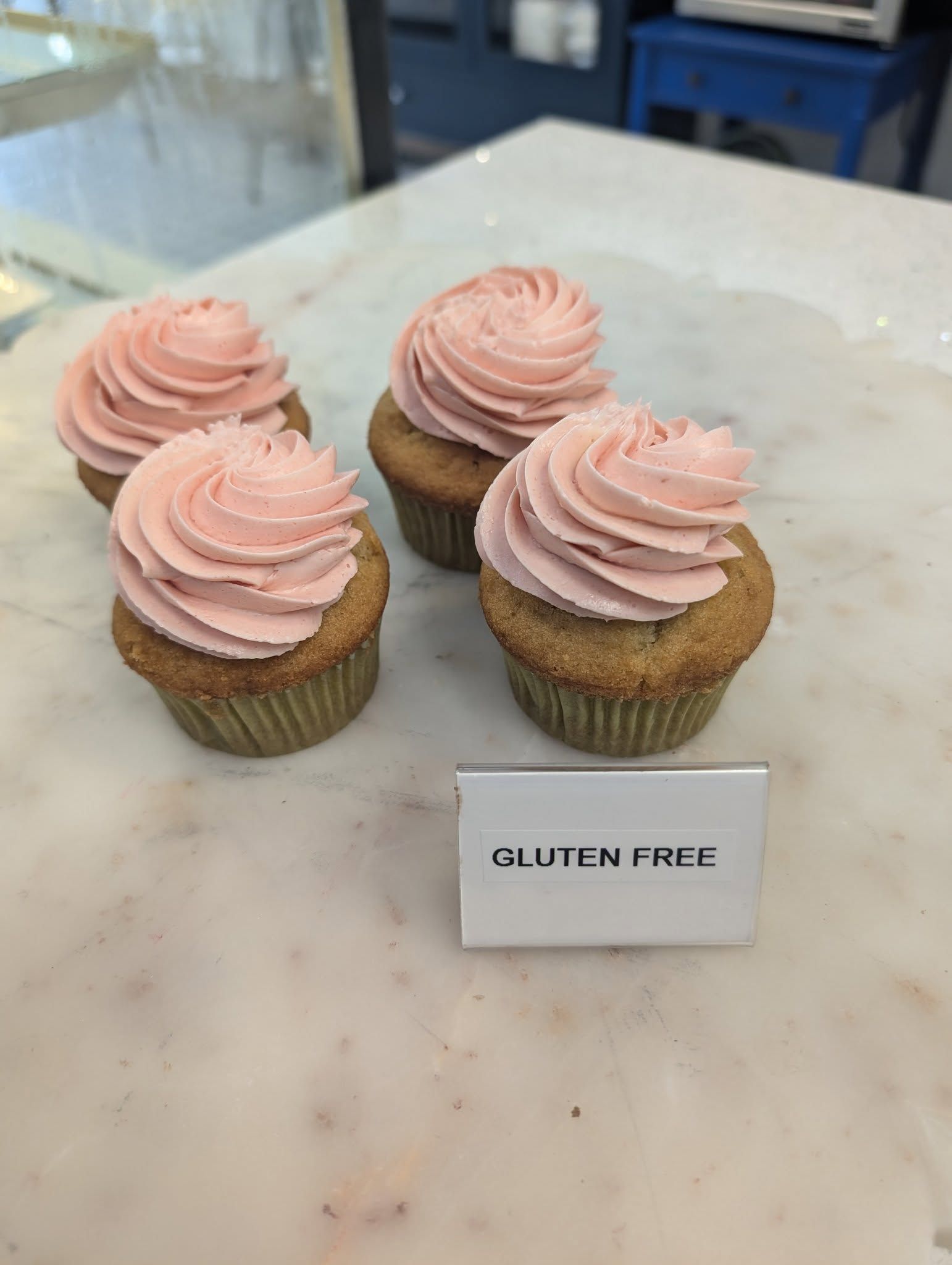 A display of cupcakes with pink frosting on a table.
