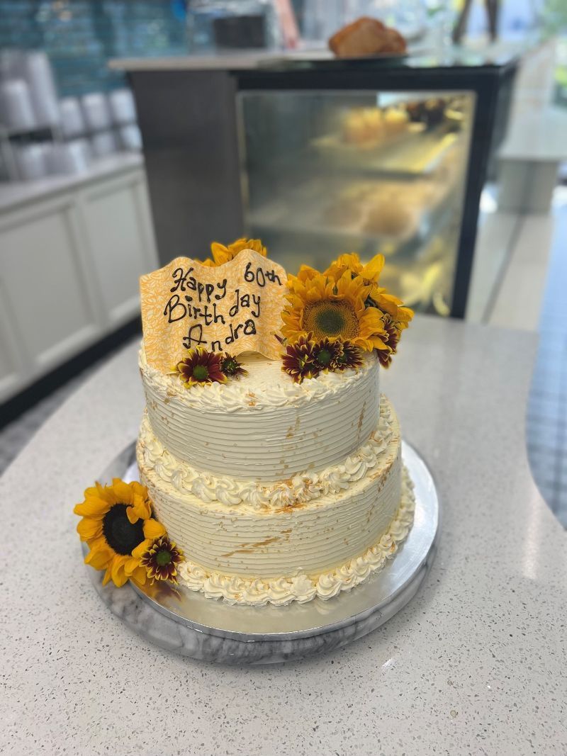 A cake with sunflowers on it is on a table.