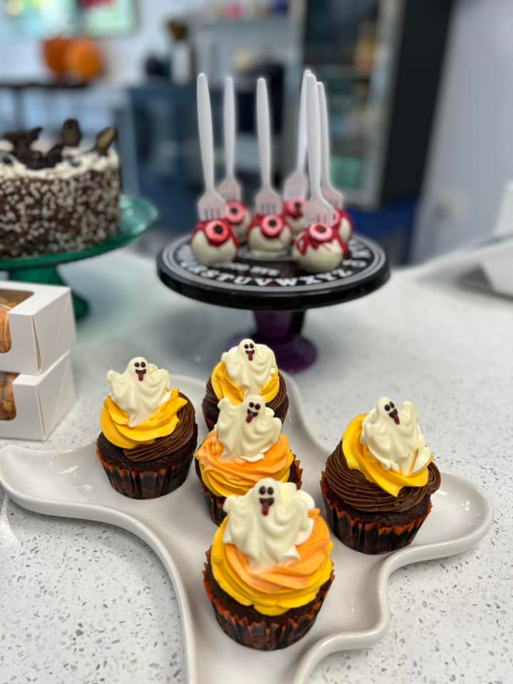 A white plate with cupcakes and cake pops on it