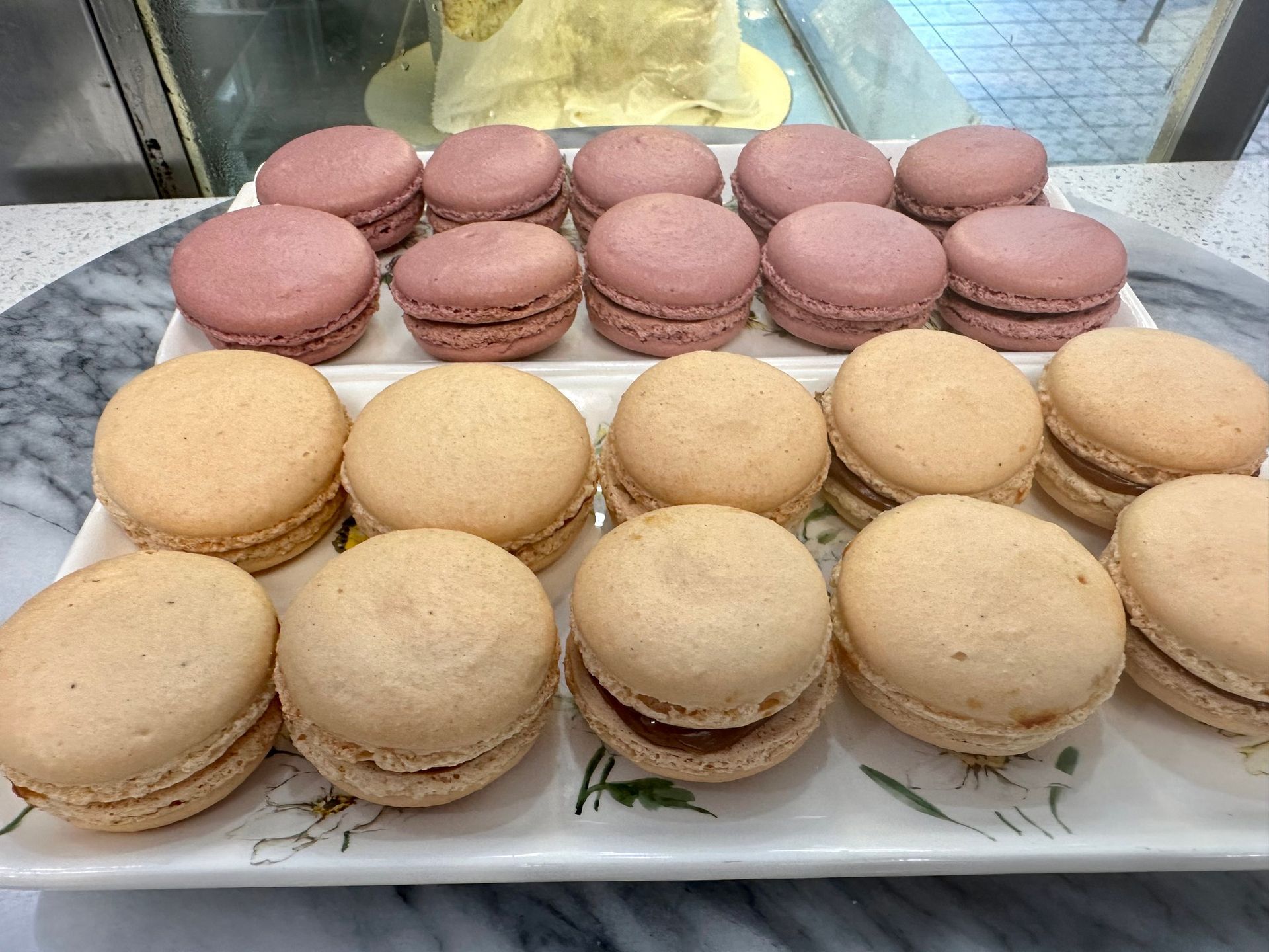 A white plate topped with a variety of macarons.