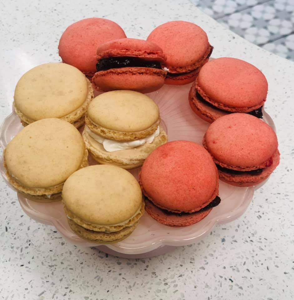 A plate of macarons with different flavors on a table