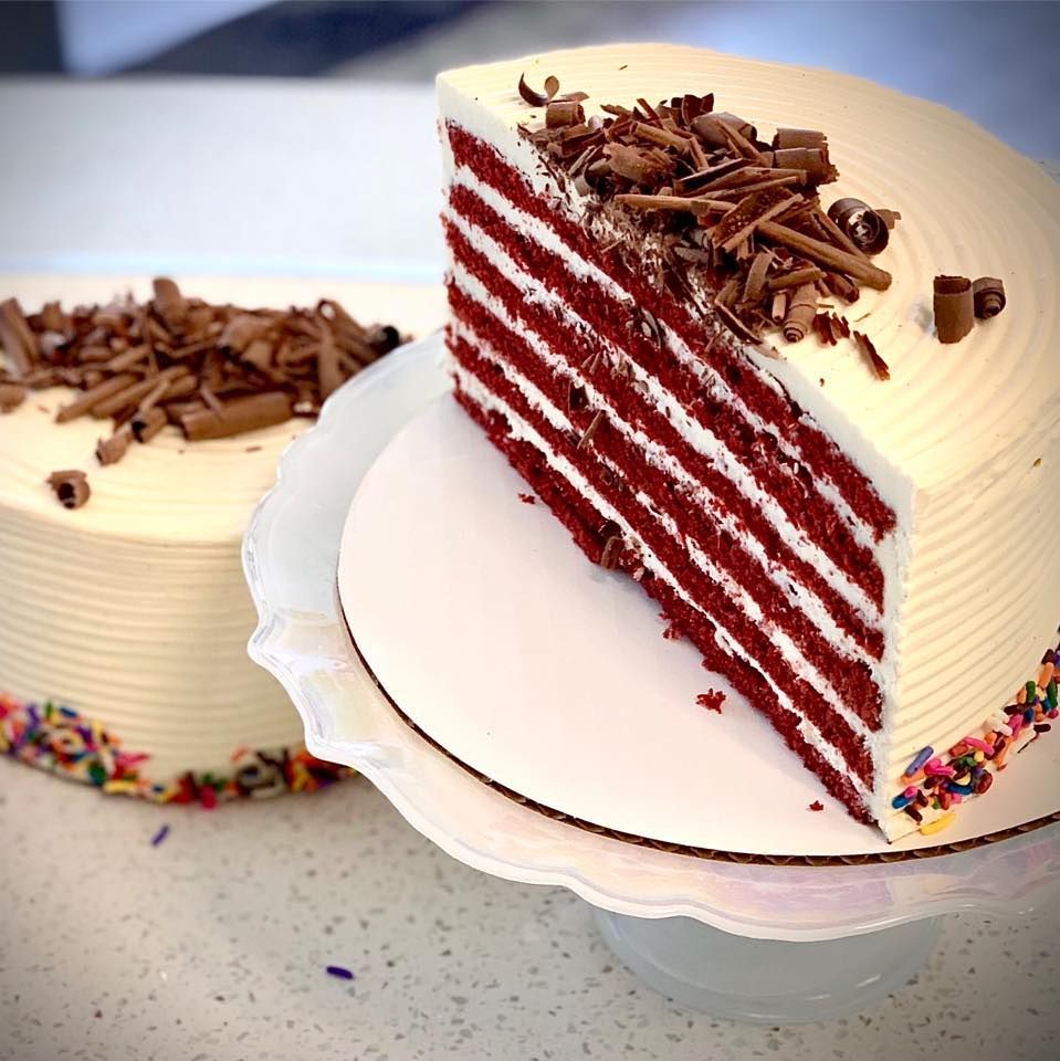 A red velvet cake with a slice taken out of it