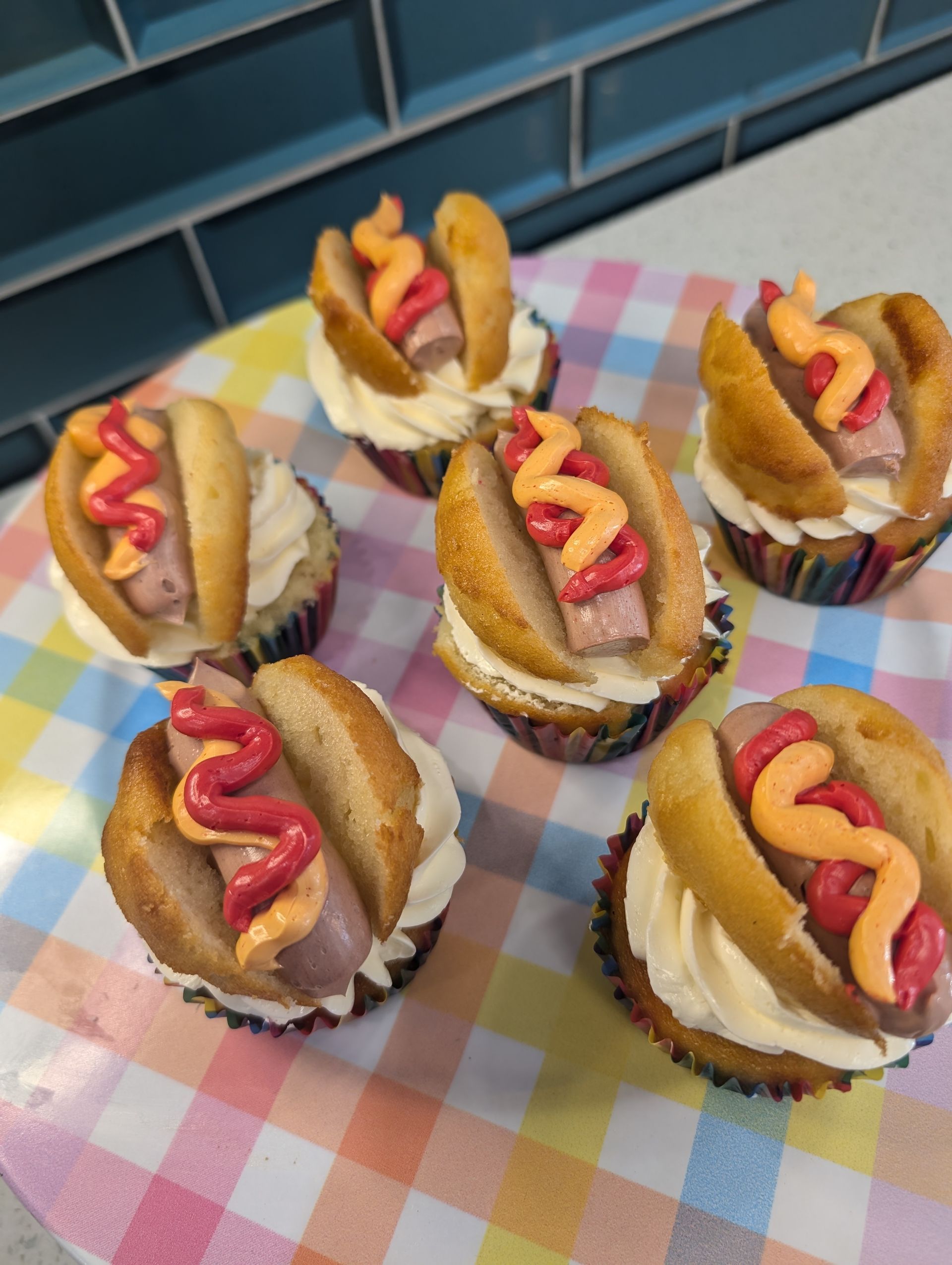 A bunch of hot dog cupcakes are sitting on a table.