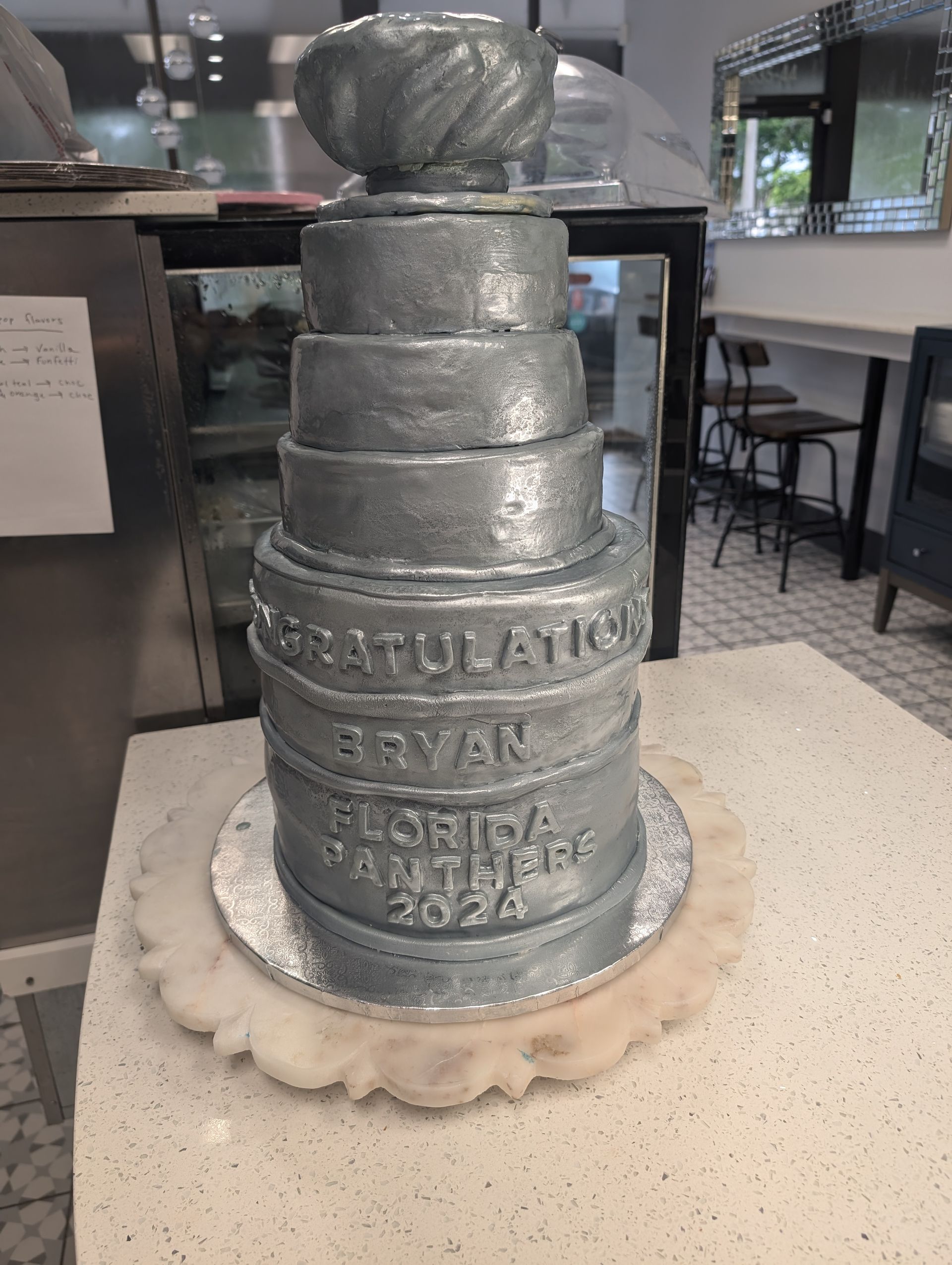 A cake that looks like a hockey trophy is sitting on a table.