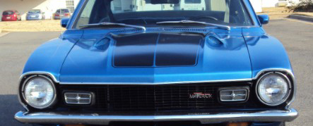 Front view of a blue classic Ford Maverick car with chrome bumper and hood scoop