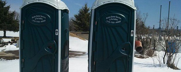 lined up green portable toilets outdoor