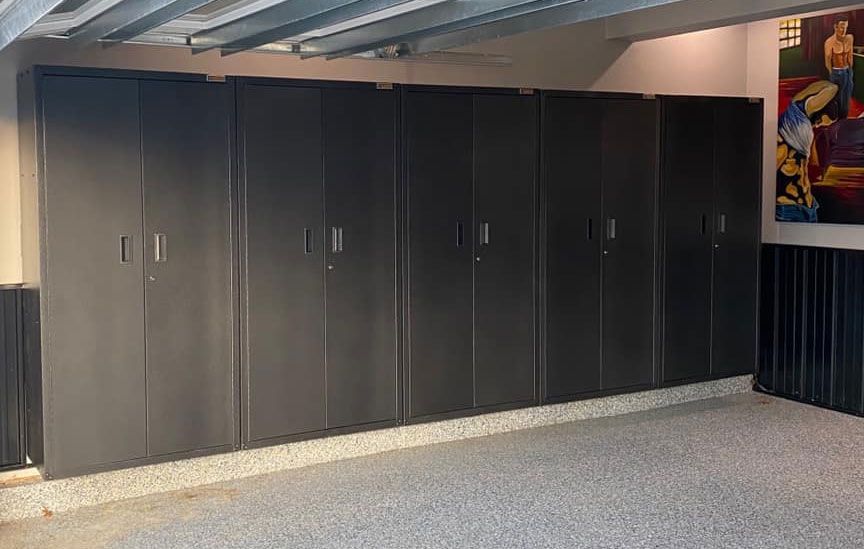 Row of tall, dark gray storage cabinets along a wall in a garage.