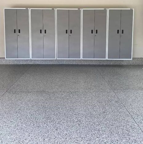 Five gray storage cabinets against a wall, above a gray speckled garage floor.